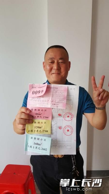 抽签后亮出自己的房号,分房户开心不已。