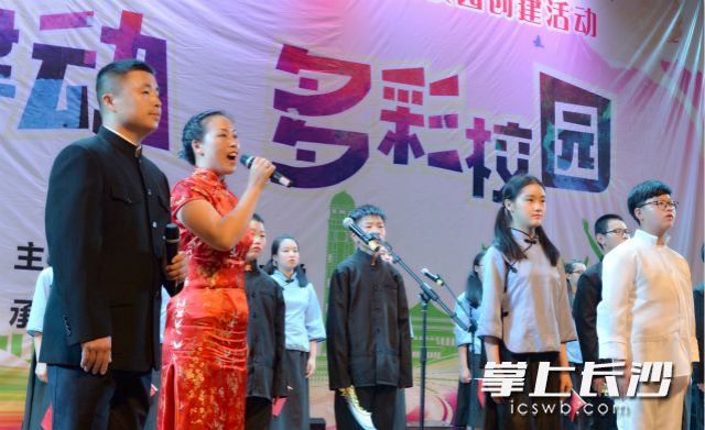 市民王先生(左一)一家三口与其他学生同台表演朗诵。