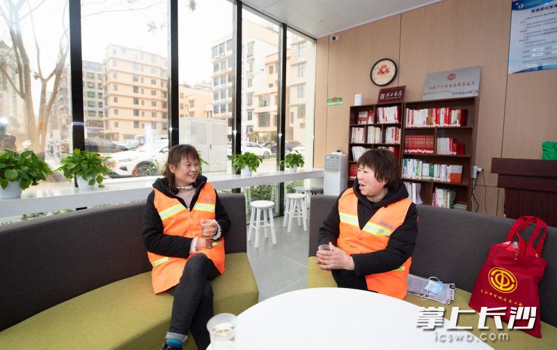 两位环卫工人正在雷锋驿站休息.