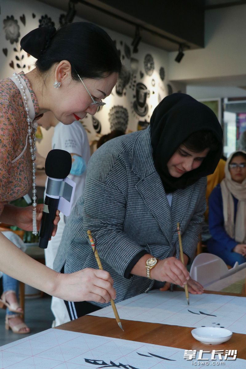 李爱莲(左)教留学生练习“女书”。 李爱莲(左)教留学生练习“女书”。