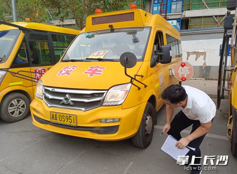 一名专业检查人员正在对校车进行仔细检查。