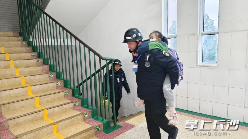 两位保安轮流接力背着女孩上楼。 两位保安轮流接力背着女孩上楼。