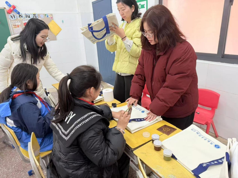 几名学生在老师指导下进行帆布包设计。 几名学生在老师指导下进行帆布包设计。