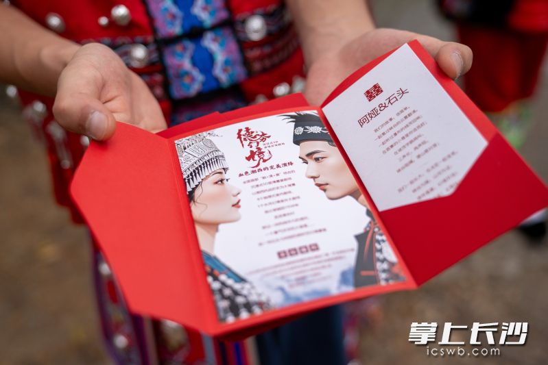 活动现场派发婚礼请柬,邀请市民前往湘西德夯,感受别具一格的苗家喜宴与苗族婚俗文化。 活动现场派发婚礼请柬,邀请市民前往湘西德夯,感受别具一格的苗家喜宴与苗族婚俗文化。