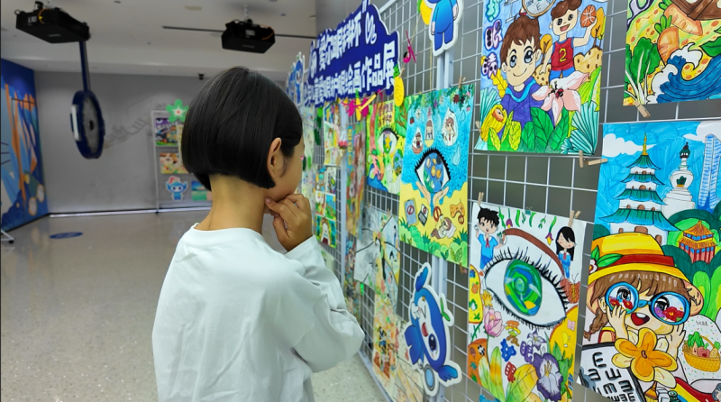 阿迪拉·阿力木驻足观看儿童绘画作品。 阿迪拉·阿力木驻足观看儿童绘画作品。
