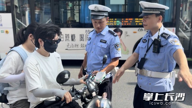 7月29日,交警在路面查处电动自行车不戴头盔违法行为。 7月29日,交警在路面查处电动自行车不戴头盔违法行为。