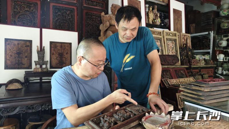 杨露红和朋友探讨文物修复工作。 杨露红和朋友探讨文物修复工作。