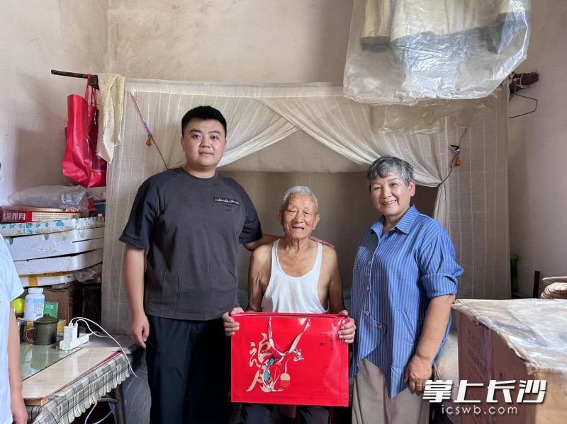 杨壮壮（左）和高燕（右）为95岁老人彭本初送上月饼和节日祝福。均为受访者供图