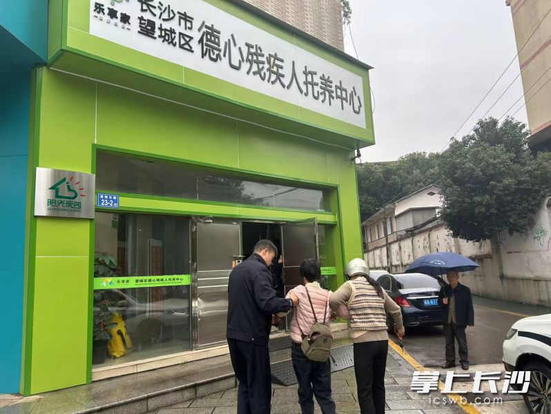 望城交警帮助母亲将女儿搀扶进残疾人托养中心。 望城交警供图 望城交警帮助母亲将女儿搀扶进残疾人托养中心。 望城交警供图
