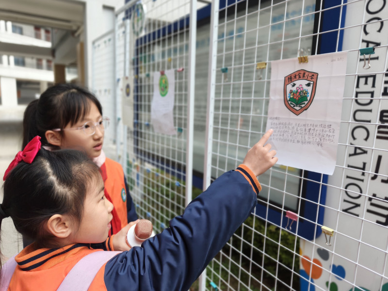 一名同学在向校园小记者介绍自己设计的新校徽。 一名同学在向校园小记者介绍自己设计的新校徽。