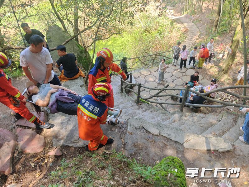 消防员用担架救助崴脚女子。 消防员用担架救助崴脚女子。