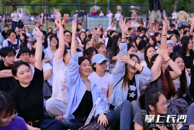 草坪席地而坐,学生们沉浸式参与音乐节。 草坪席地而坐,学生们沉浸式参与音乐节。