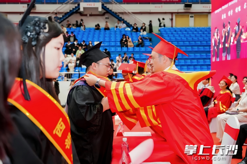 学校负责人为西部计划志愿者佩戴绶带,为他们送上祝福。 学校负责人为西部计划志愿者佩戴绶带,为他们送上祝福。