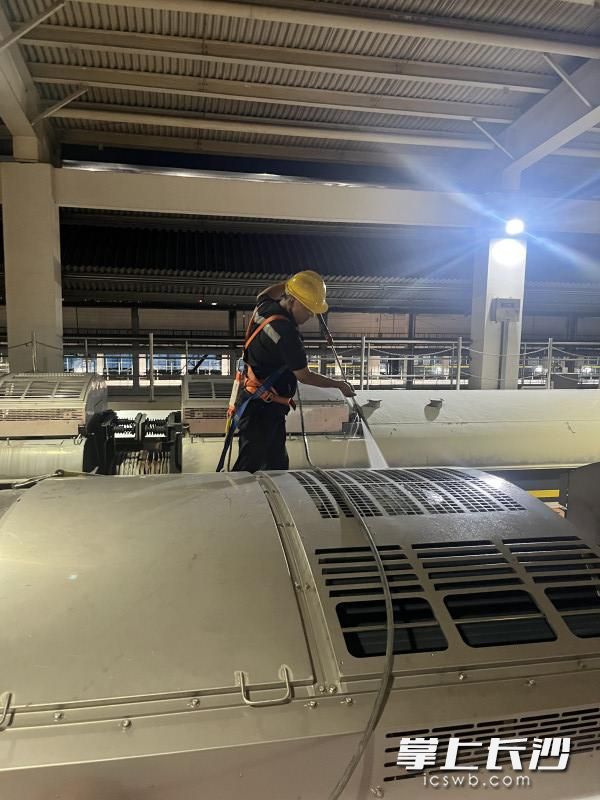 在车顶使用高压水枪逐台冲洗泠凝器。 在车顶使用高压水枪逐台冲洗泠凝器。
