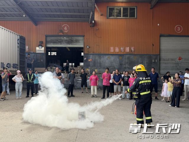 消防员现场演示灭火器使用方法。 消防员现场演示灭火器使用方法。