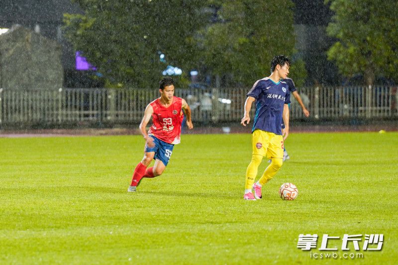 长沙队队员杨椰文与湖南师范大学球员进行防守突抢。