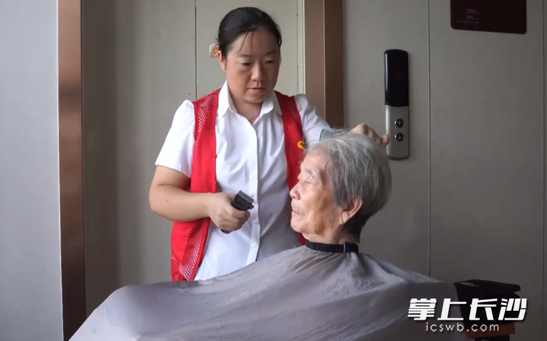 正在为周奶奶理发的向冰。市民政局 供图 正在为周奶奶理发的向冰。市民政局 供图