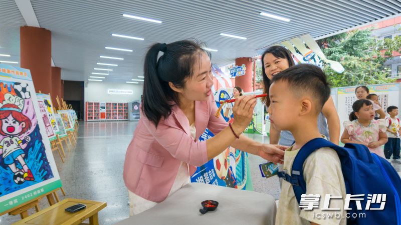 长塘里小学,校党总支书记肖陈慧为报道新生“点朱砂”。 长塘里小学,校党总支书记肖陈慧为报道新生“点朱砂”。