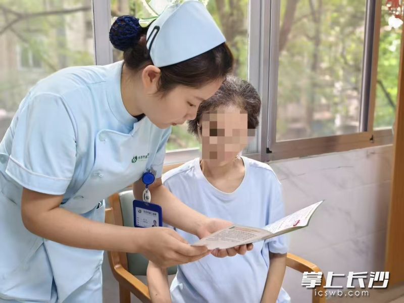 安宁疗护病房费英与患者家属交流中。 医院供图