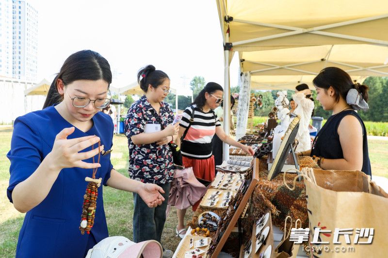 活动现场，10余个摊位一字排开，吸引市民游客驻足。