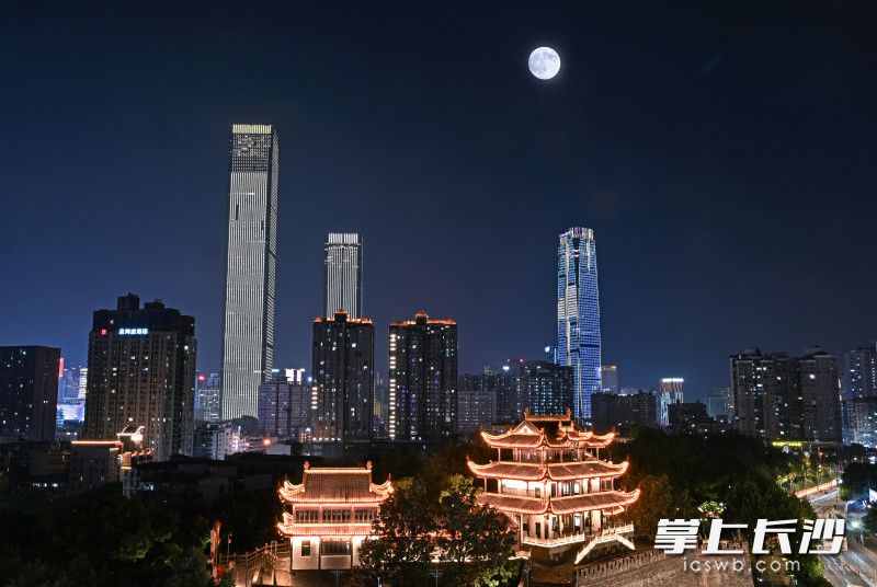 今晚8时许，天心阁光影公园后方，一轮满月升上城市夜空，与光影流转的古阁、璀璨的万家灯火交相辉映。（二次曝光） 均为长沙晚报全媒体记者王志伟摄