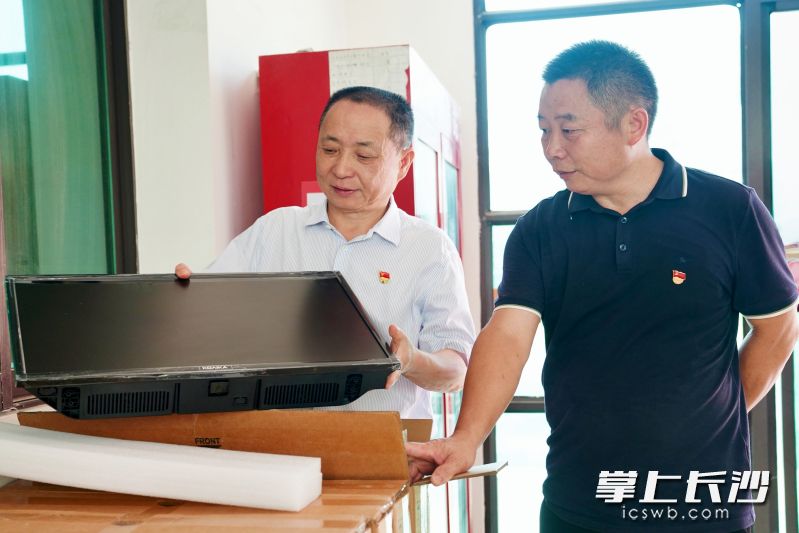 陈基良（左）向敬老院捐赠50台电视机。