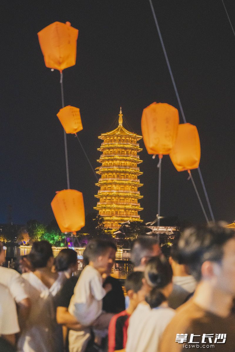 千灯祈福现场,夜色之中,漫天孔明灯造型灯盏高悬空中,游人齐聚灯下赏灯许愿,感受浓厚的中秋国风氛围。