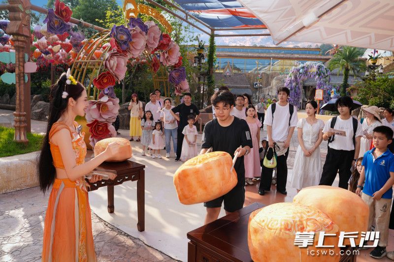 市民游客正在玩游戏,搬运巨型月饼。
