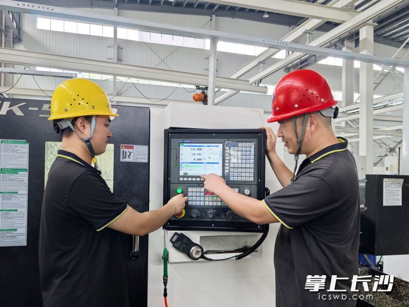 在天和钻具精密制造车间，车间主任靖金昌（右）指导工人操作。 均为长沙晚报全媒体记者张禹摄