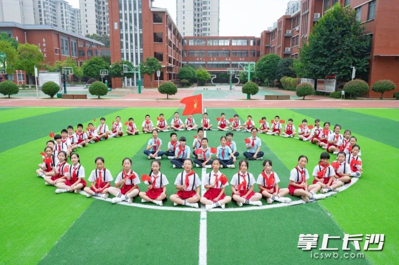 操场上,红领巾映衬国旗红。 操场上,红领巾映衬国旗红。
