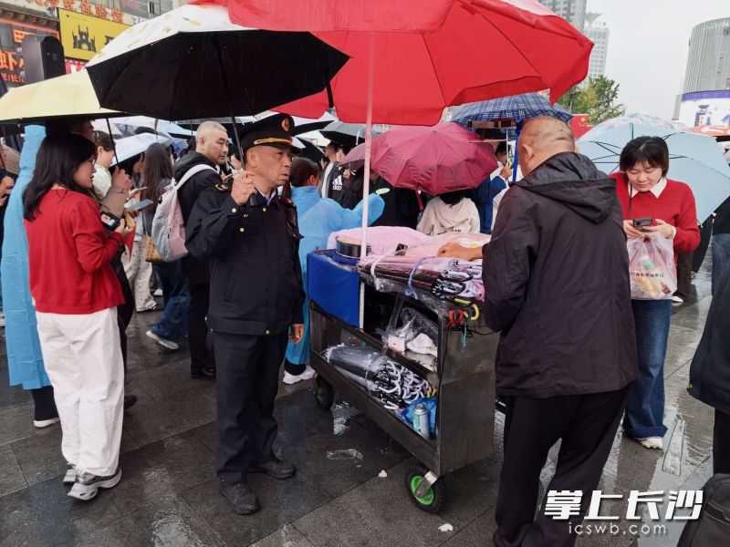 10月3日，执法人员劝离占道摊贩。