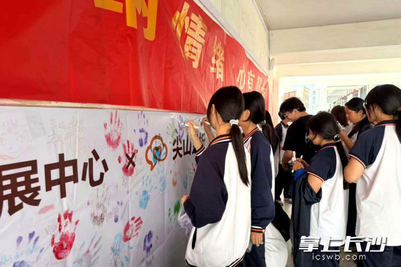同学们挑选颜料,用掌印和寄语,表达自己的情绪和心愿。 同学们挑选颜料,用掌印和寄语,表达自己的情绪和心愿。