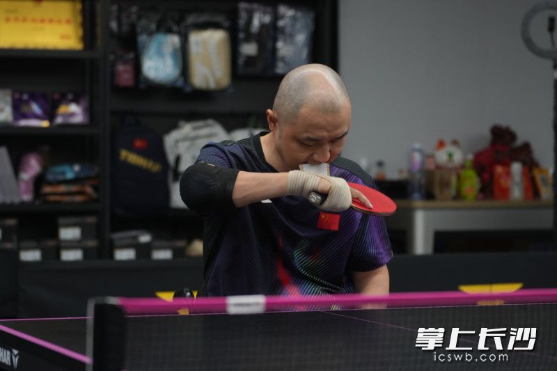 因为手部力量匮乏，陈勇必须依靠绑带固定球拍。