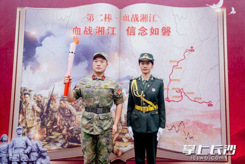 第1棒火炬手、于都采火少年代表006432号“雷小锋”刘紫萱（右）与第2棒火炬手、退役军人孟凡棣交接火炬。 均为通讯员 肖奥 供图