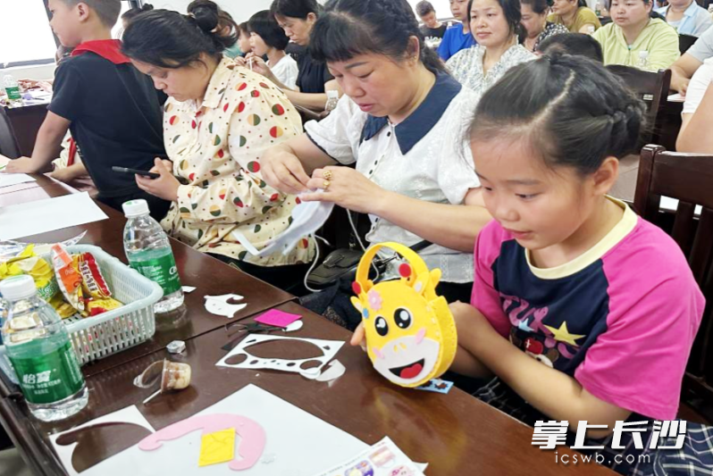 亲子家庭围坐桌前开展手工制作活动。