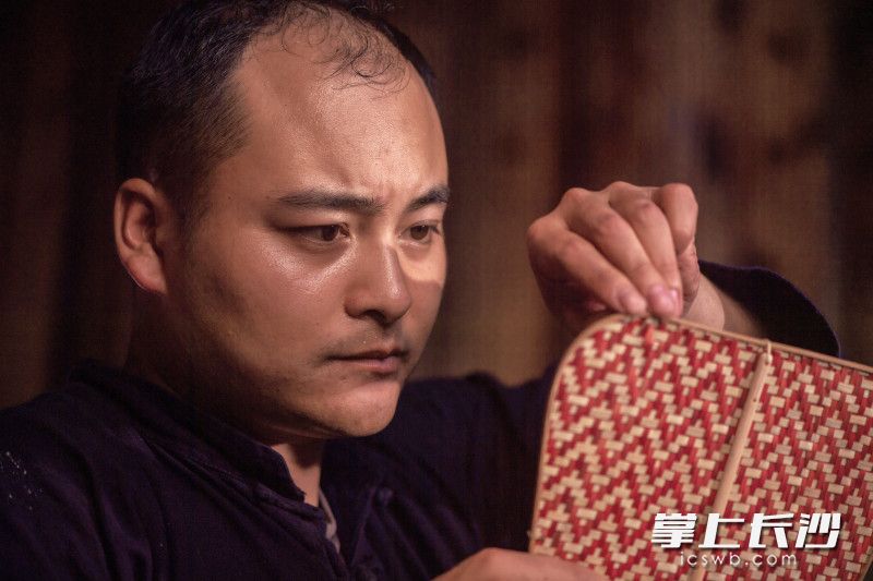 他侧过脸,眼睛几乎贴到篾面上,一根一根地看松紧。竹编讲一个“匀”字,一处松了,整片就歪。这样的端详,在竹艺馆里一天要重复上百次。屋外是游客的脚步声,屋里只有篾条摩擦的轻响。均为长沙晚报全媒体记者 李锋 摄 他侧过脸,眼睛几乎贴到篾面上,一根一根地看松紧。竹编讲一个“匀”字,一处松了,整片就歪。这样的端详,在竹艺馆里一天要重复上百次。屋外是游客的脚步声,屋里只有篾条摩擦的轻响。均为长沙晚报全媒体记者 李锋 摄