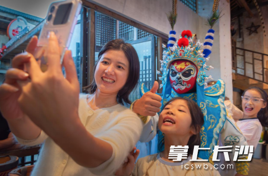 游客与变脸大师合影留念。 游客与变脸大师合影留念。